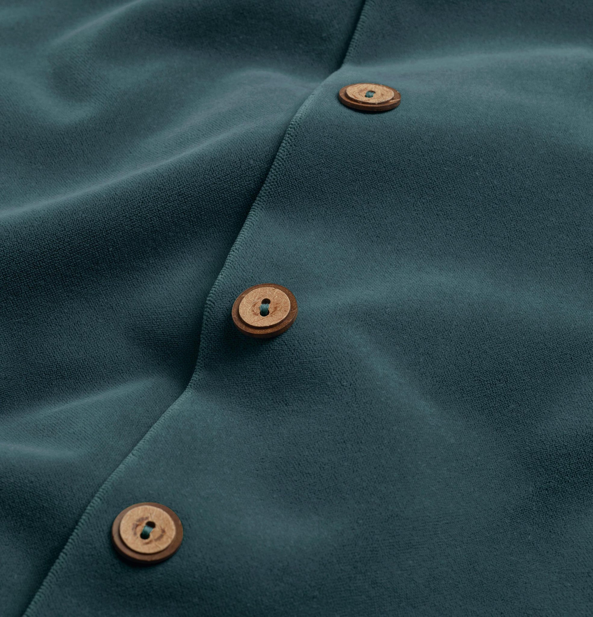 Button detail of icy teal velvet cushion
