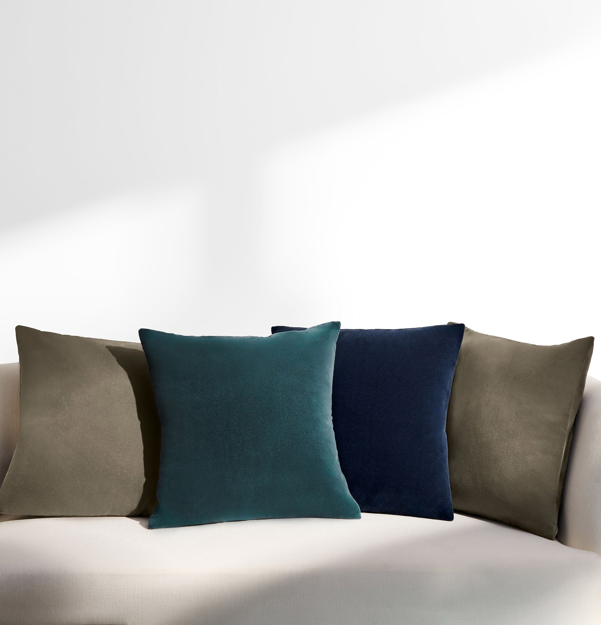 Teal, Navy and Taupe Velvet cushions on sofa